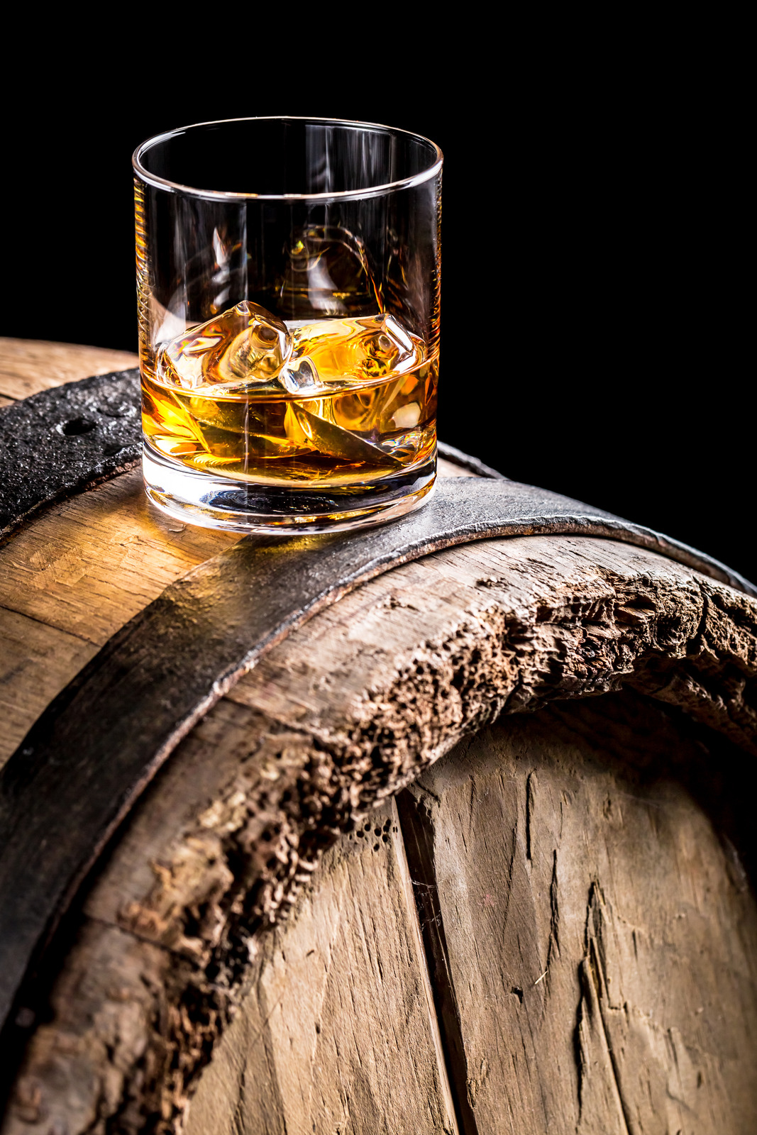Whiskey glass and old wooden barrel.