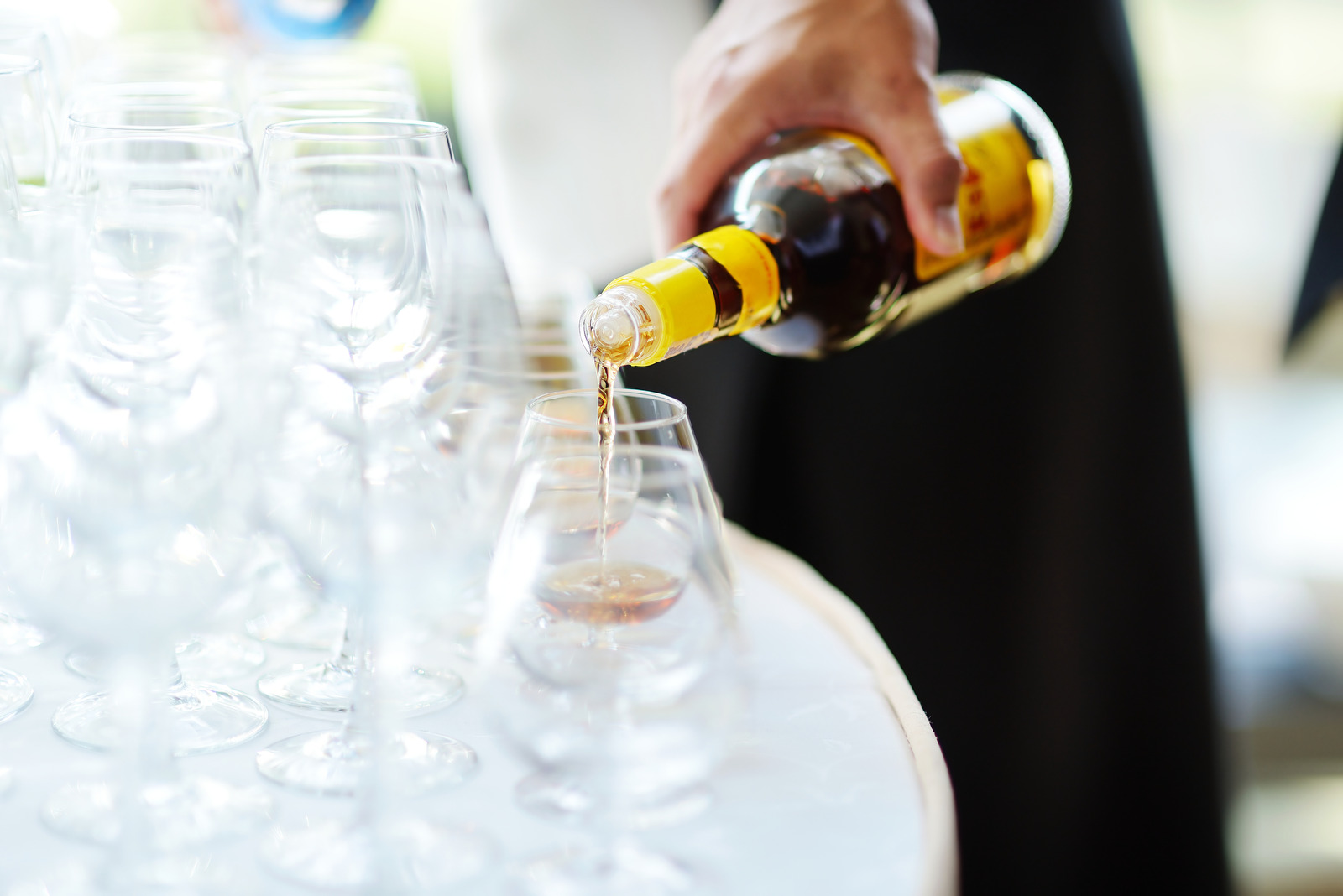 Pouring alcohol into a glasses on a festive event, party or wedding reception