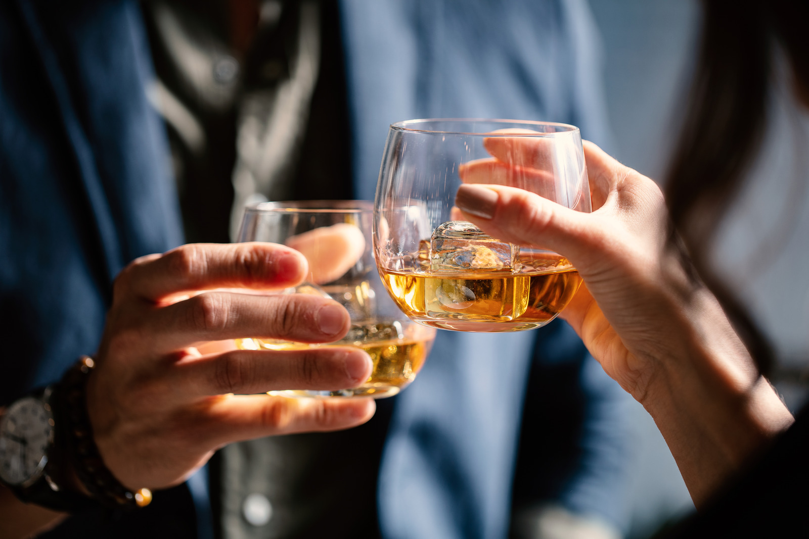 Man and woman celebrating with wiskhey glasses.